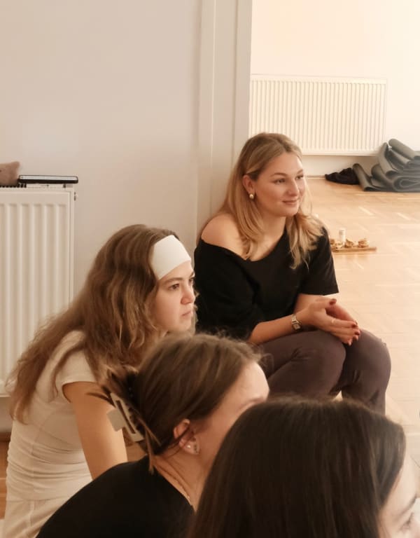 Résztvevők egy korábbi LélekPihenő workshopon, a földön ülve beszélgetnek